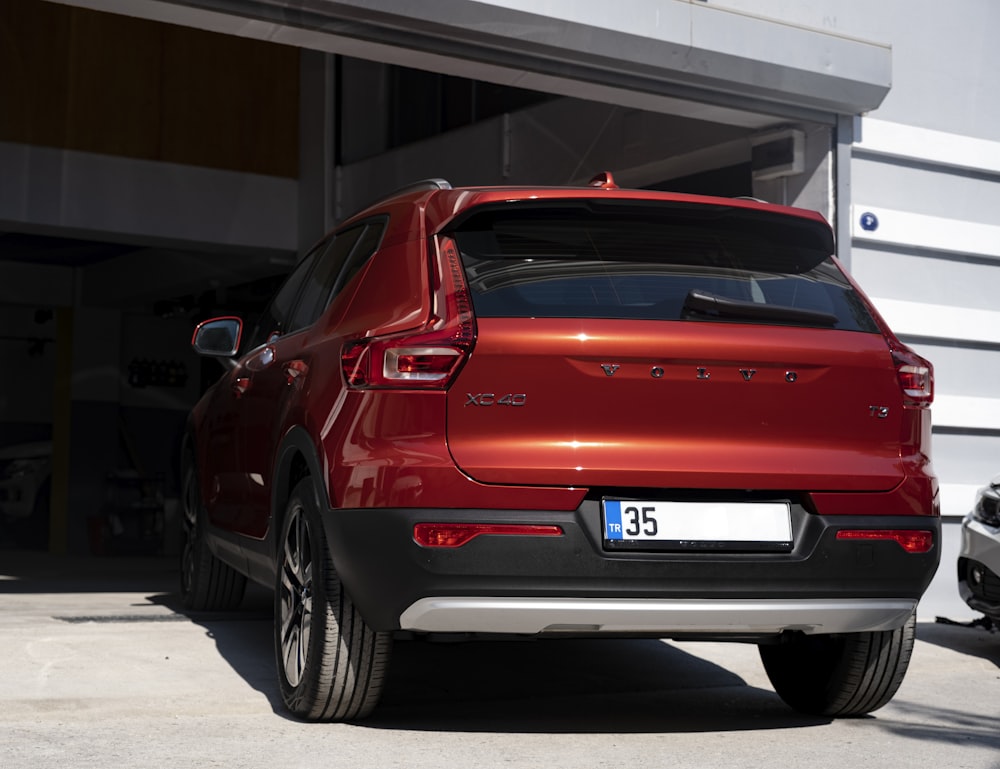 a red suv parked in front of a building