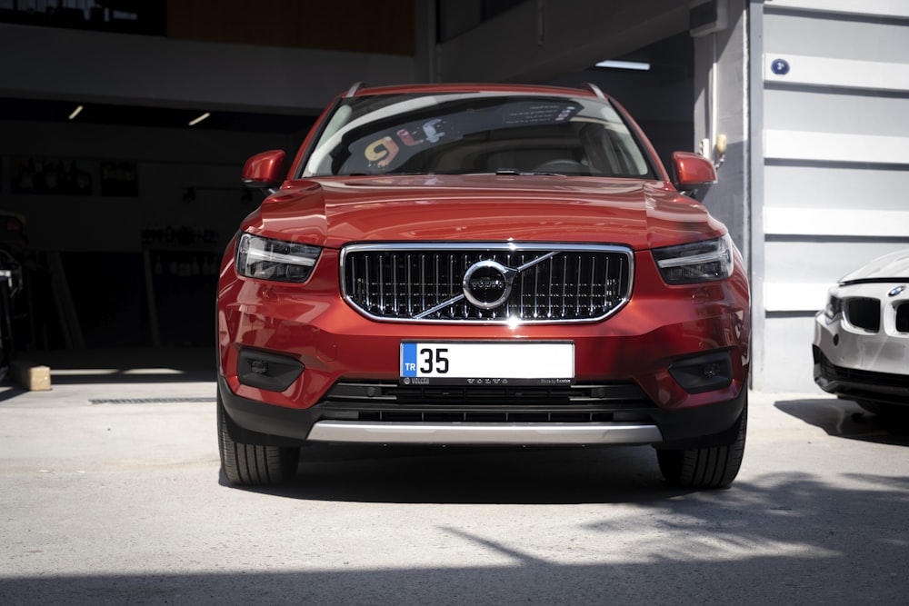 a red volvo car parked in a garage