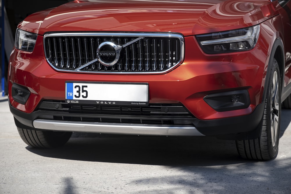 a red volvo car parked in a garage