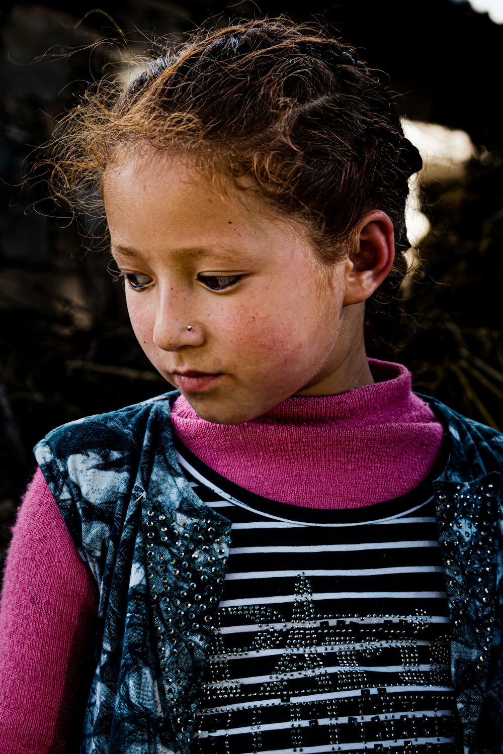 a young girl is looking down at something