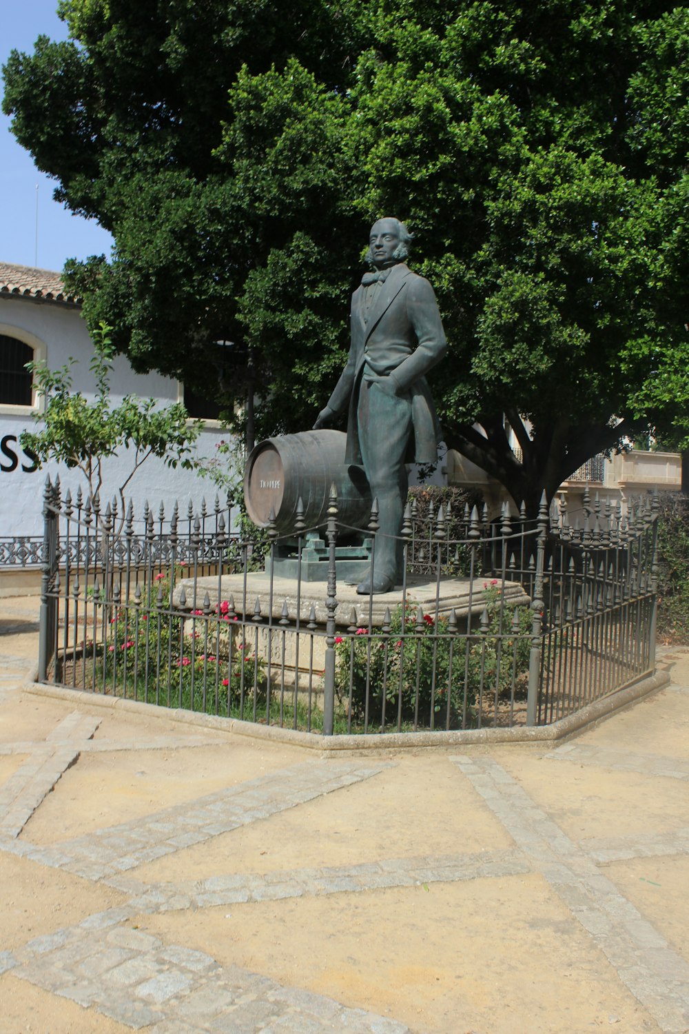 a statue of a man with a dog in front of a fence