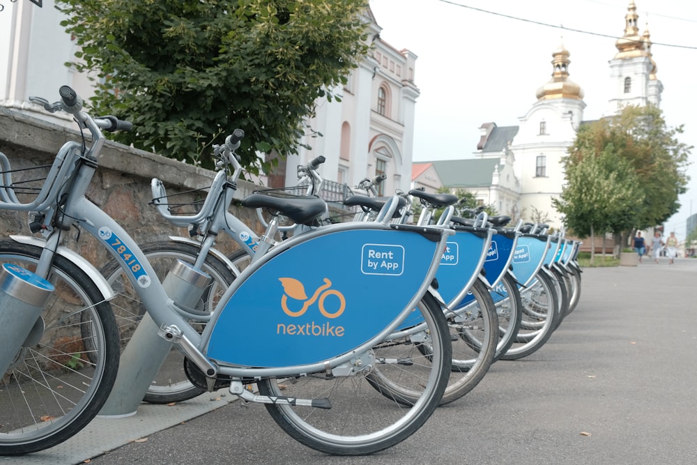 una hilera de bicicletas estacionadas una al lado de la otra