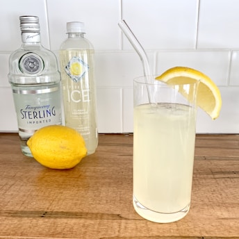 A refreshing bottle of limonceili limoncello surrounded by fresh lemons.