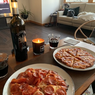 A cozy home party with guests enjoying a variety of pizzas served buffet style.