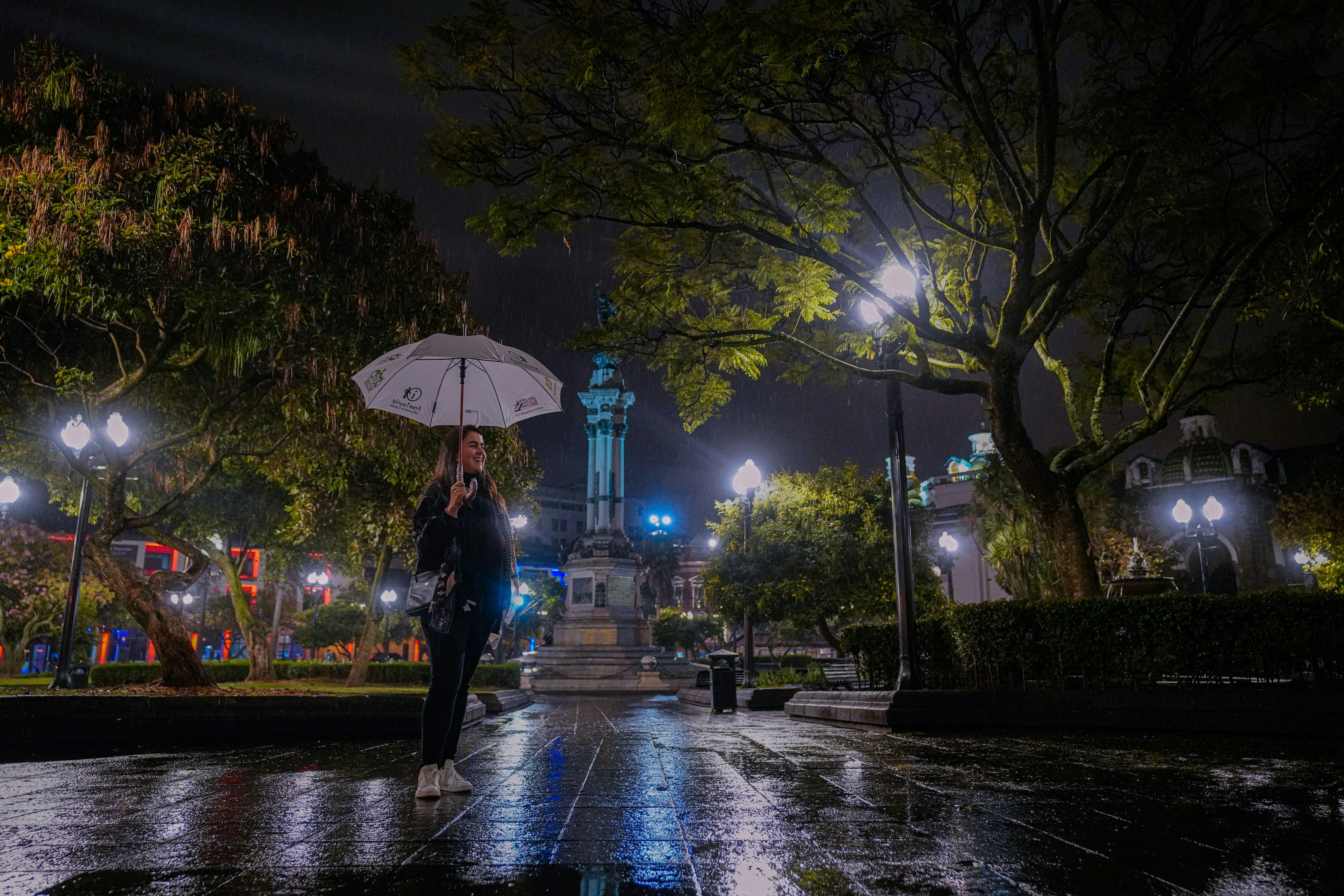 a woman holding an umbrella on a rainy night