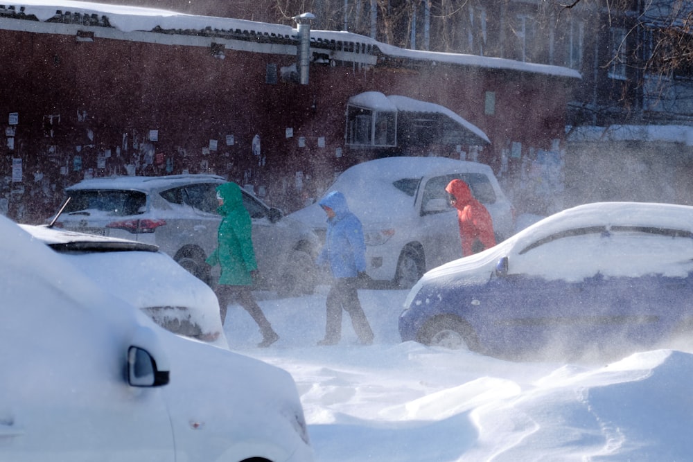 a group of people walking through a snow covered parking lot