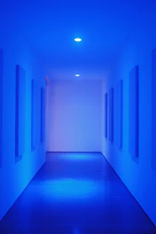 Sleek bathroom with glassmorphism design elements and glowing neon blue highlights.
