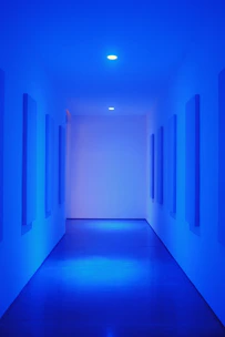 Close-up of a sleek concealed cistern integrated seamlessly behind a bathroom wall with glowing blue accents.