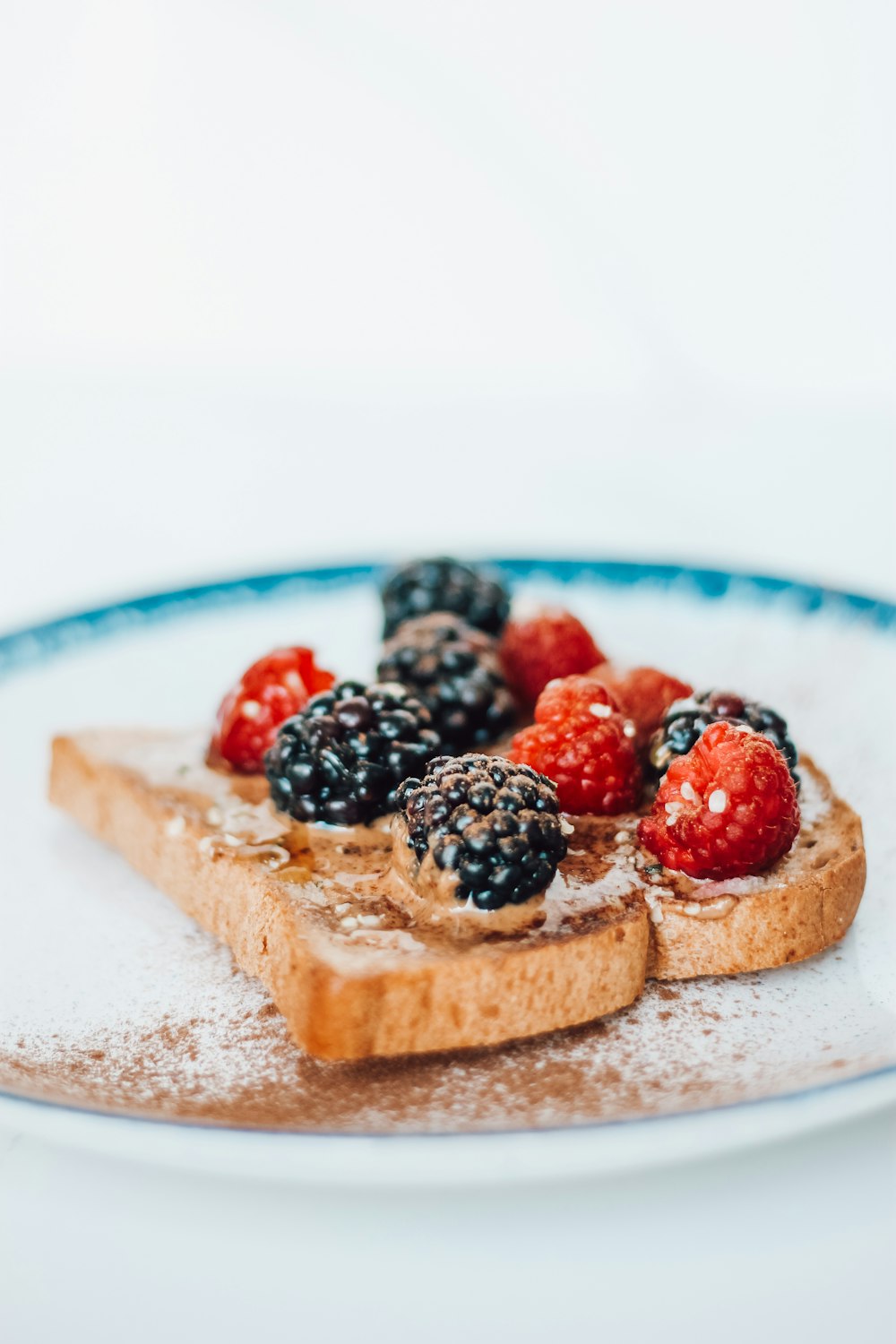a piece of toast with berries and powdered sugar on top