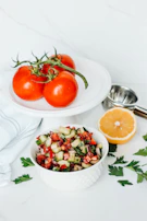 A vibrant salad bowl bursting with fresh tomatoes, cucumbers, and herbs.