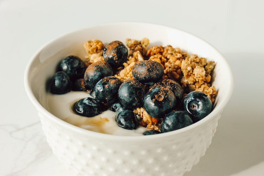 a bowl of cereal with blueberries and granola