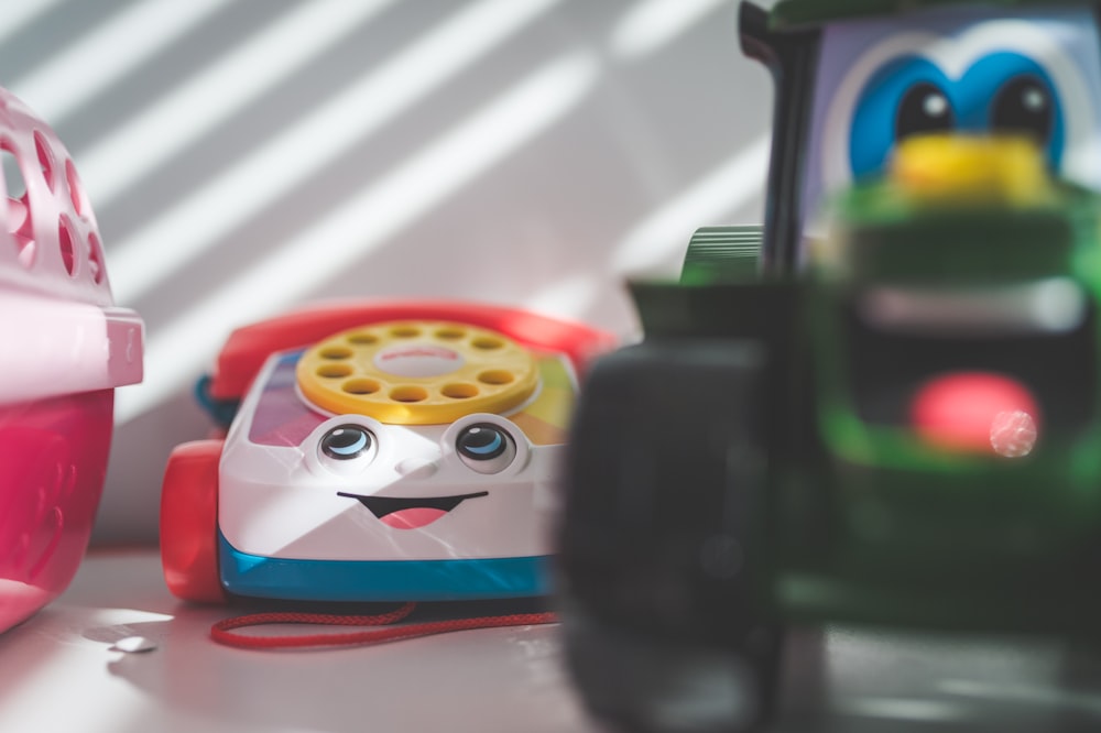 a toy phone sitting next to a toy car