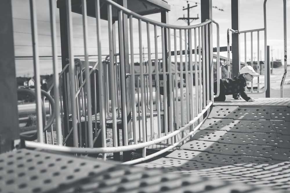 a black and white photo of a person sitting on a bench