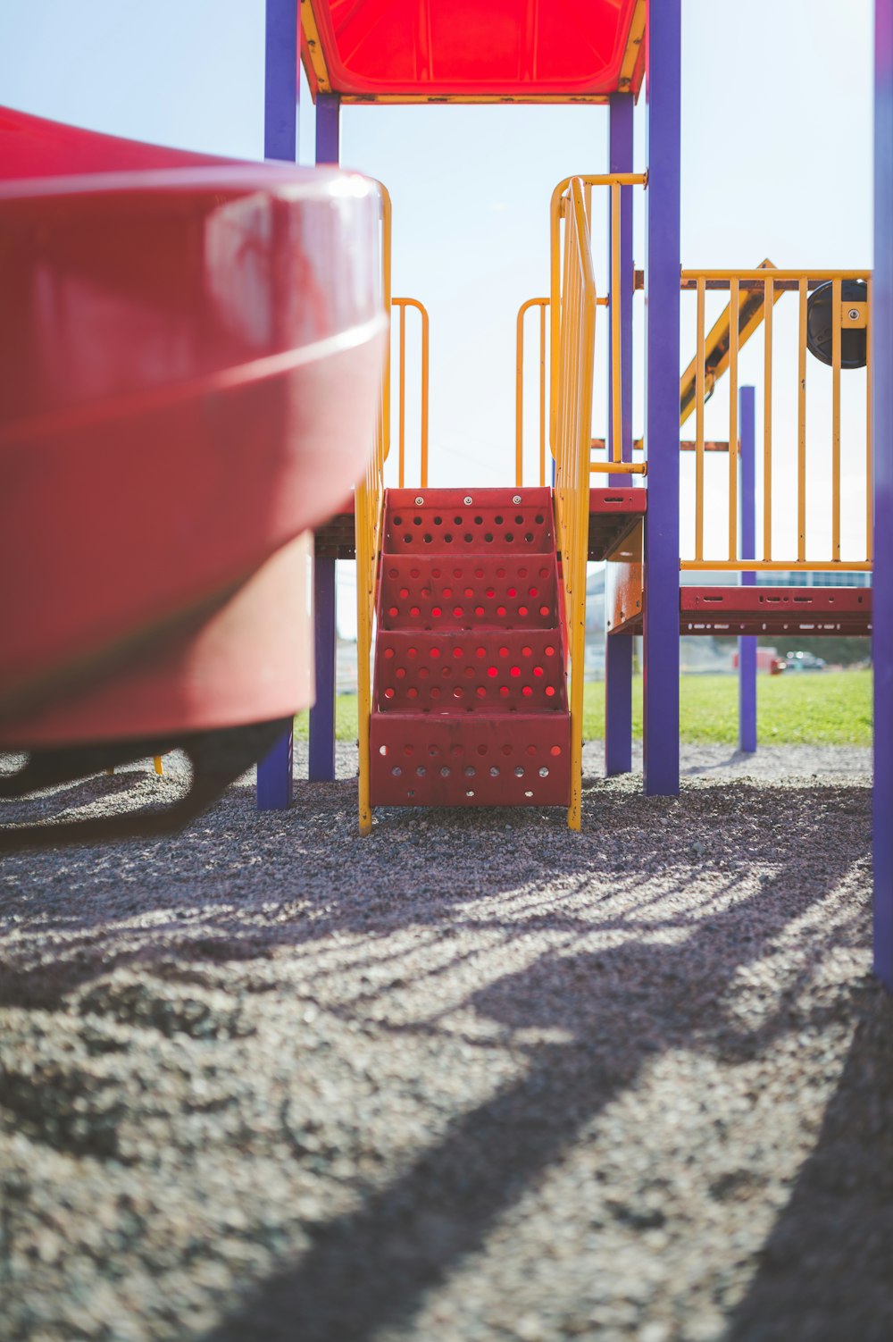 a playground with a red slide and stairs