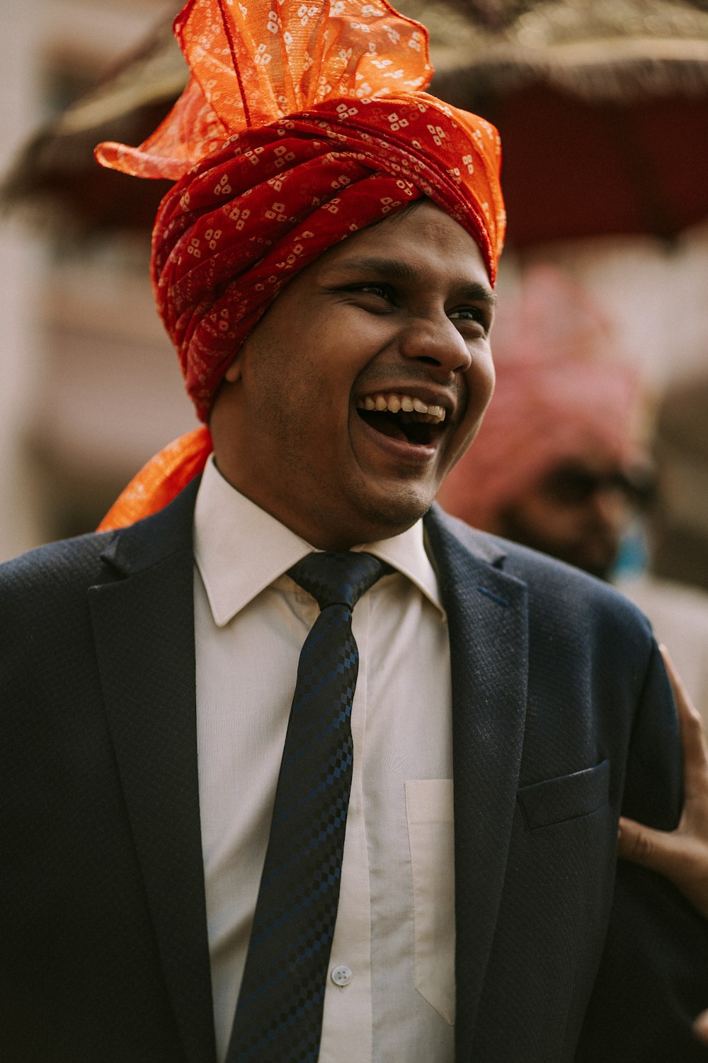 Un hombre con turbante riendo y vistiendo un traje