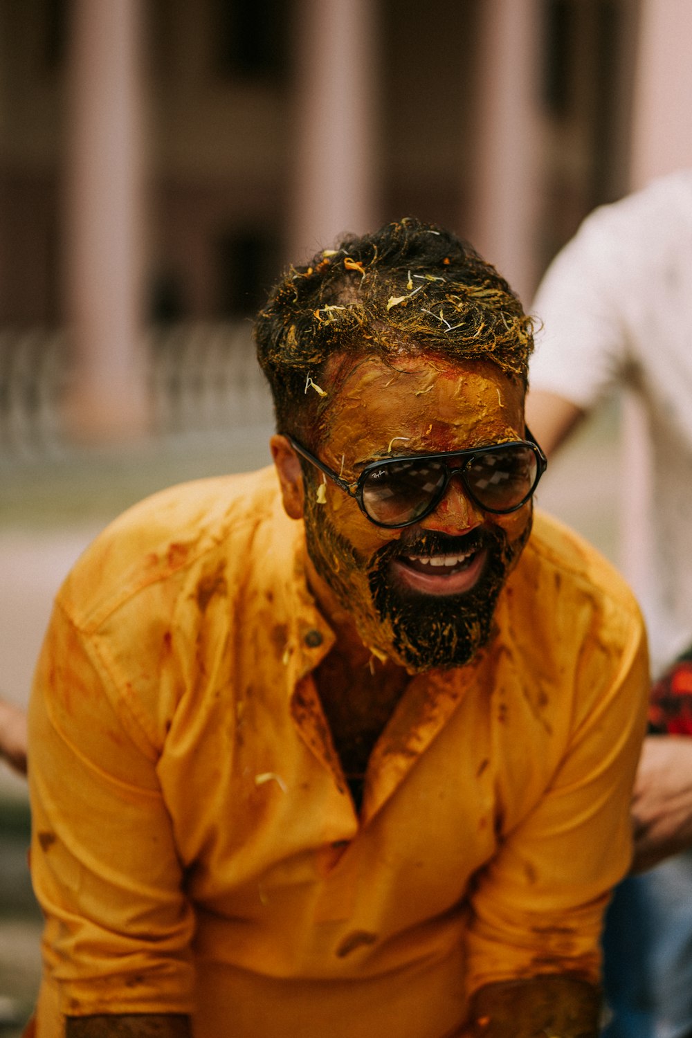 Un homme en chemise jaune et lunettes de soleil