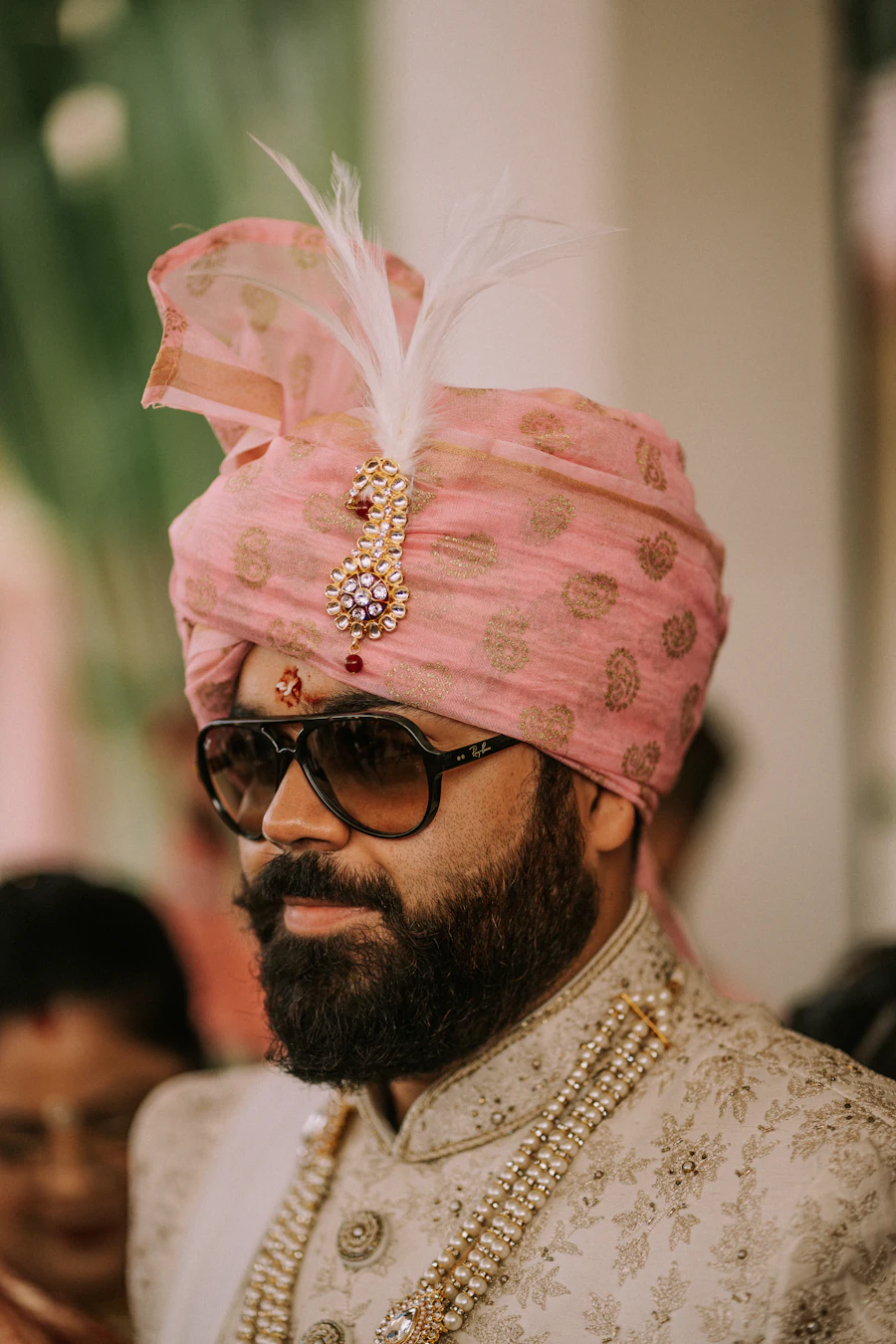 Groom wearing a pink wedding turban with kalgi and sehra