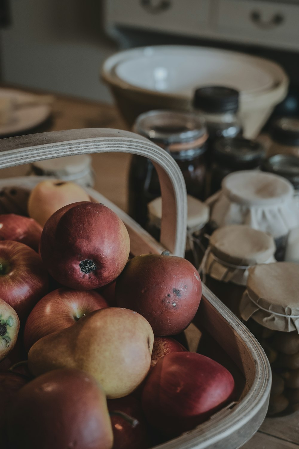 a basket of apples sitting on top of a wooden table