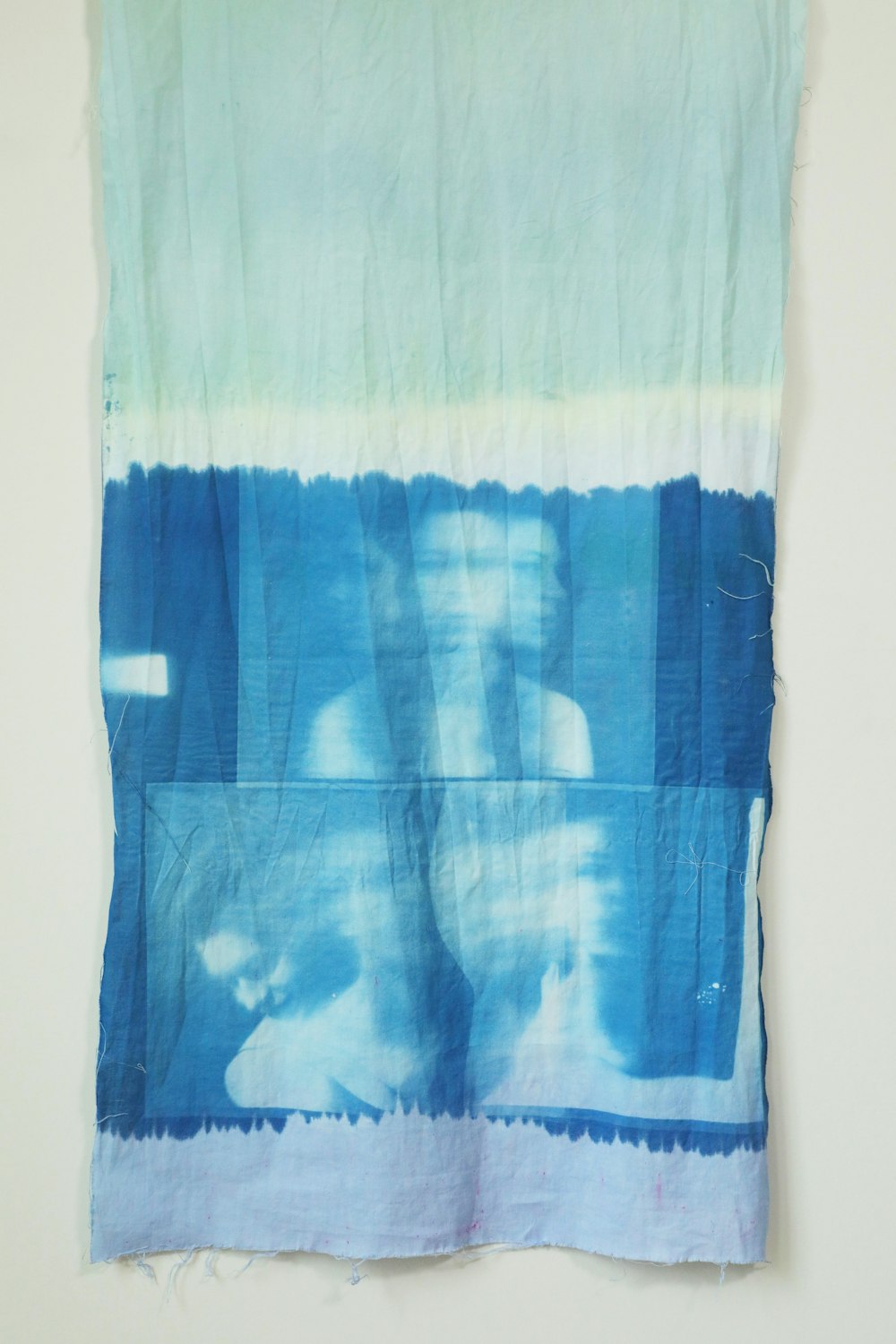 a blue and white piece of cloth hanging on a wall