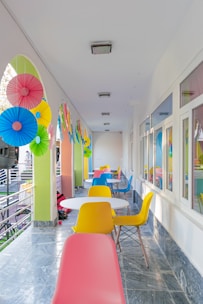 a long hallway with colorful chairs and tables
