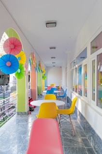 a long hallway with colorful chairs and tables