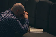 a man sitting on a couch with his hands on his face