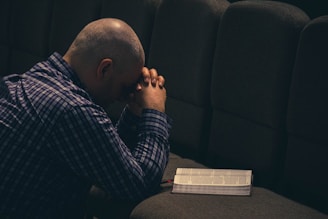 a man sitting on a couch with his hands on his face