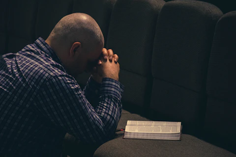 a man sitting on a couch with his hands on his face