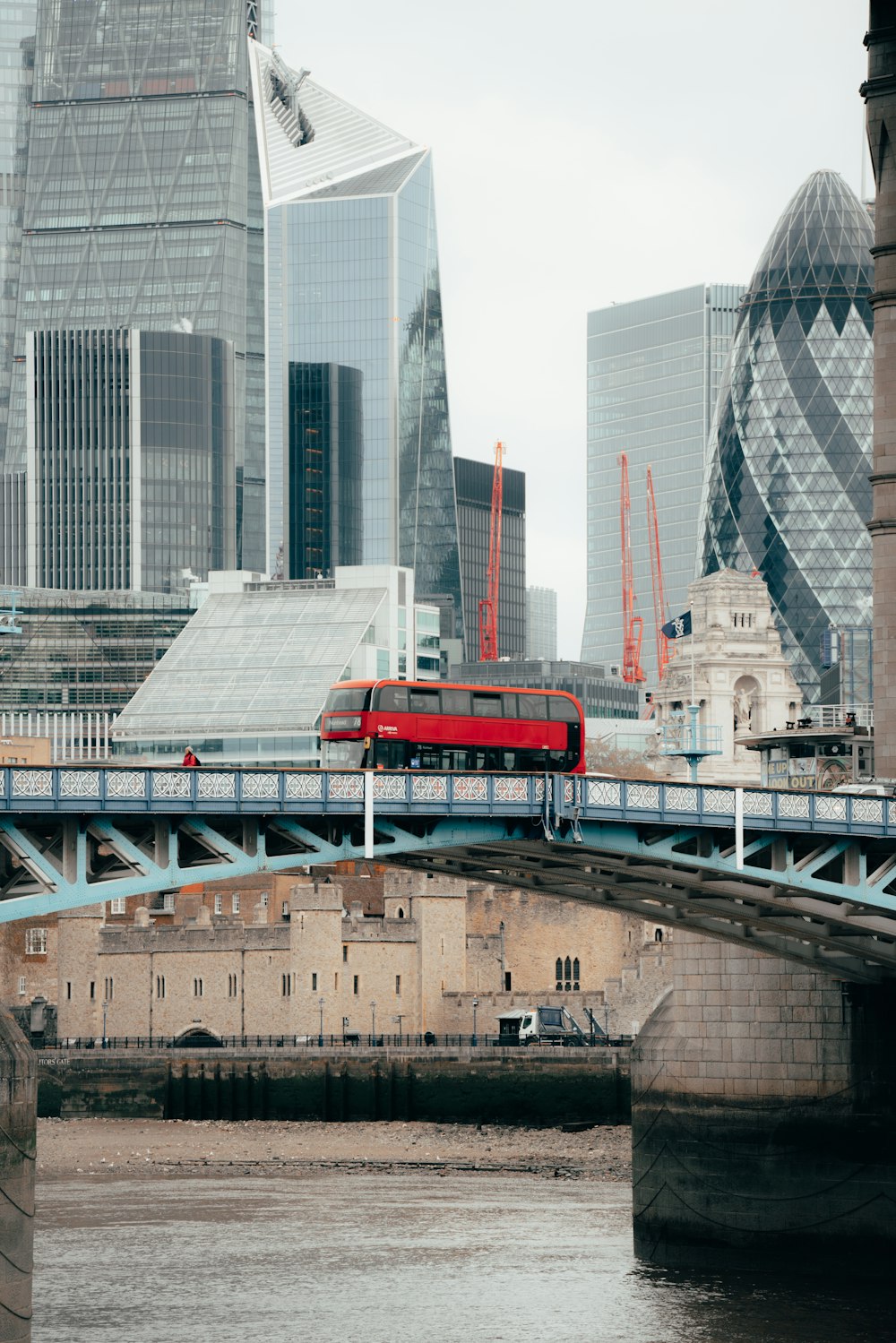 a red double decker bus traveling over a bridge