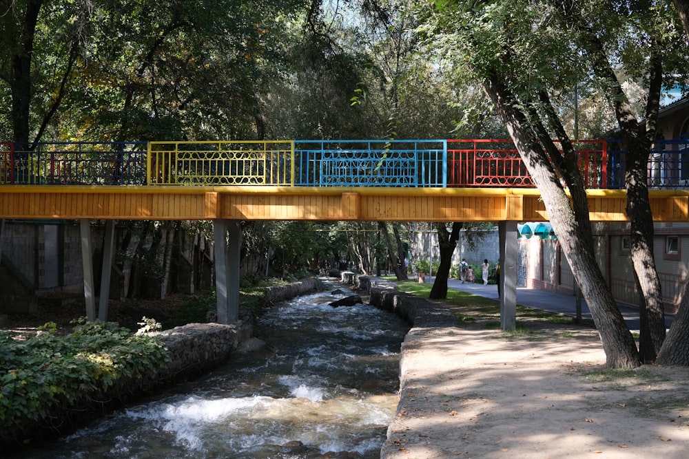 a wooden bridge over a small stream in a park