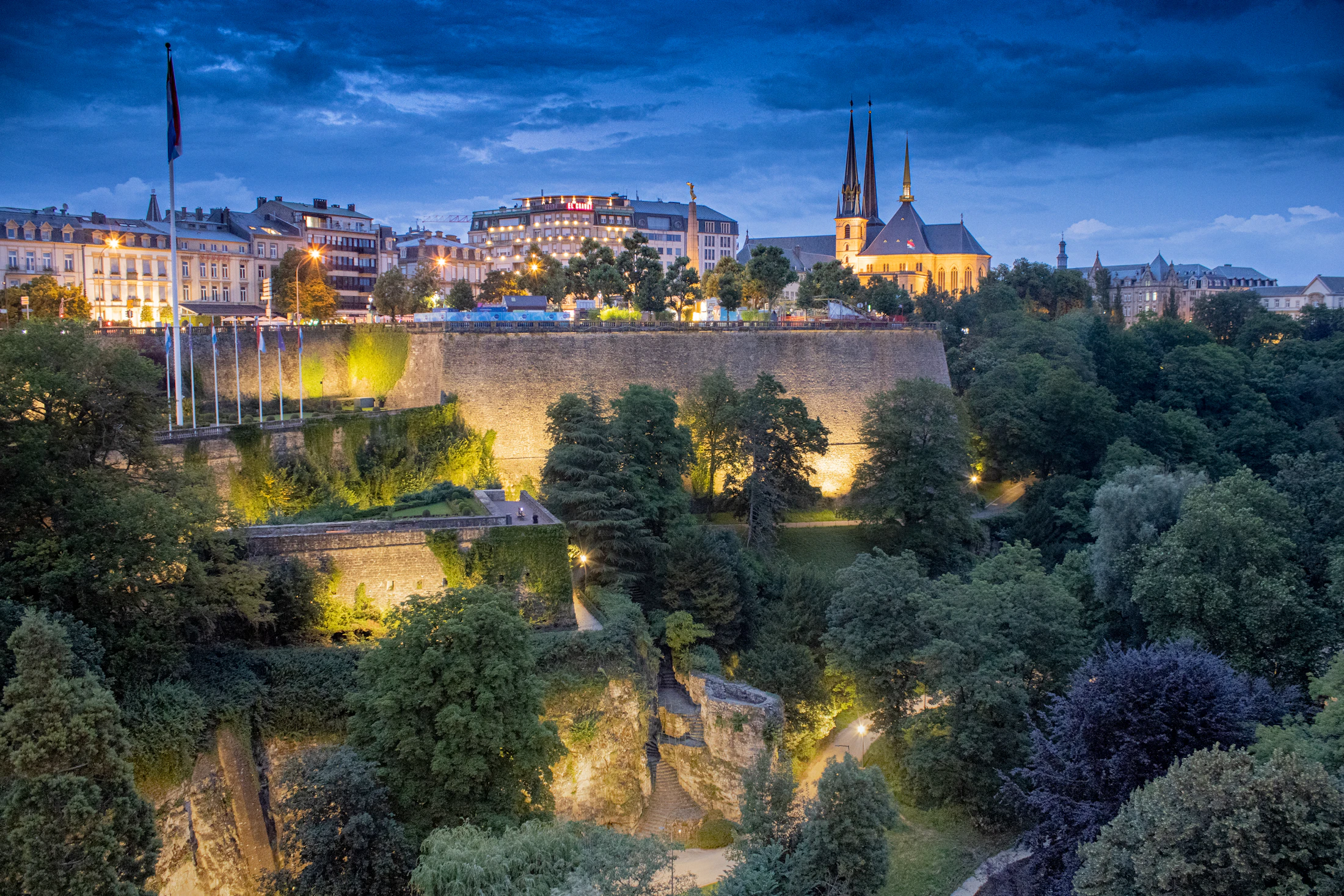 Ville perchée sur ses remparts au-dessus d’une vallée éclairée à la tombée du jour ; image d’ambiance, aucun des lieux du guide n’y figure