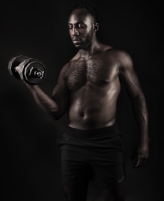 a shirtless man holding a pair of gloves