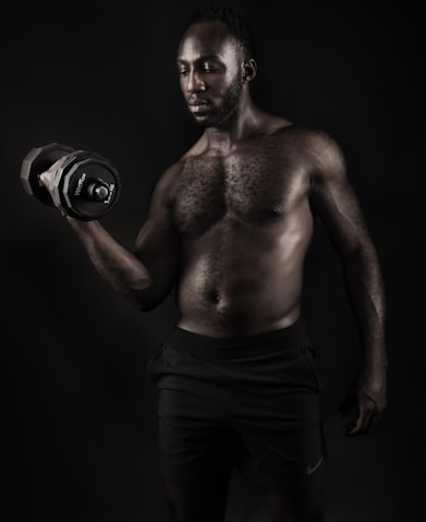 a shirtless man holding a pair of gloves