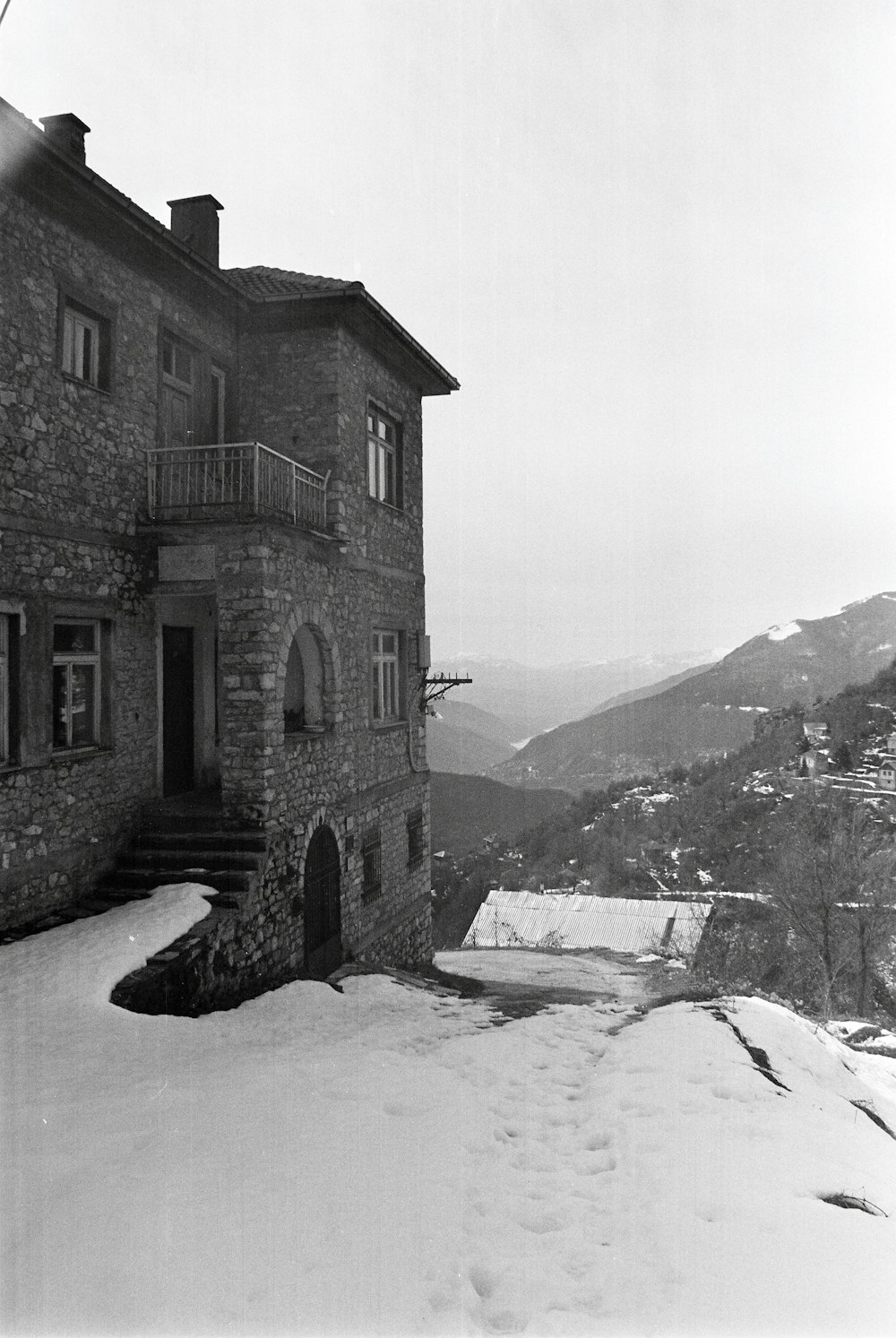 Una foto en blanco y negro de una casa en la nieve