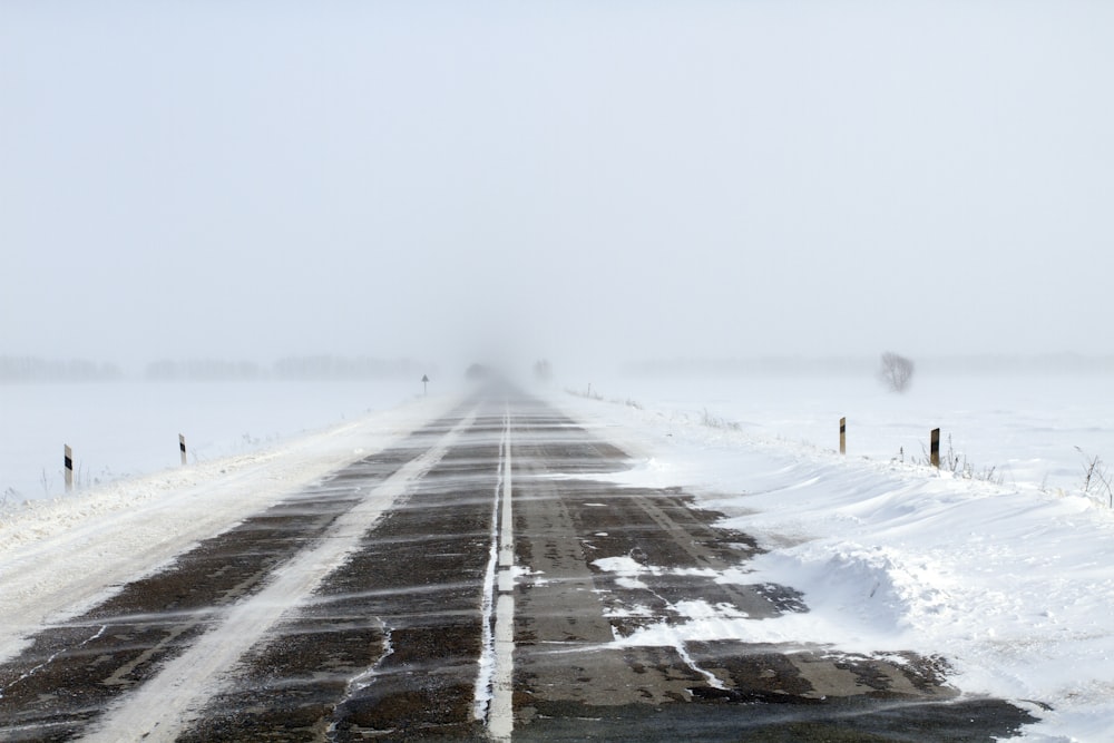 uma estrada coberta de neve no meio do nada