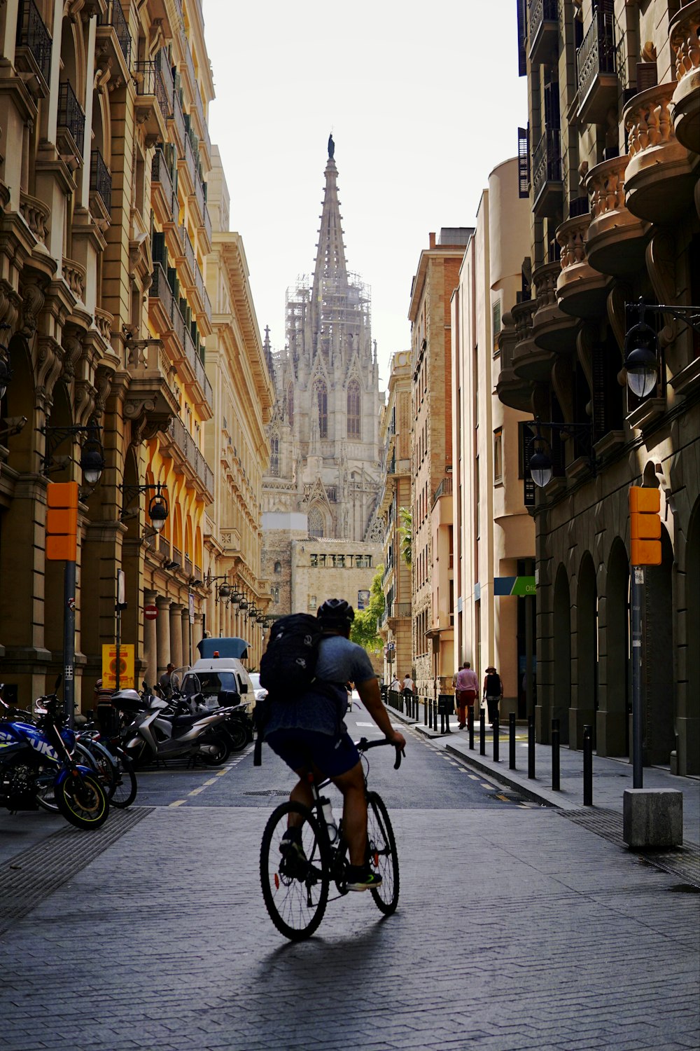 a man riding a bike down a street next to tall buildings