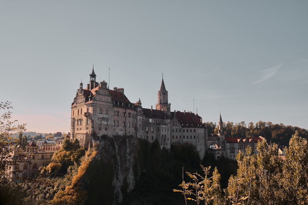 a castle on top of a hill surrounded by trees