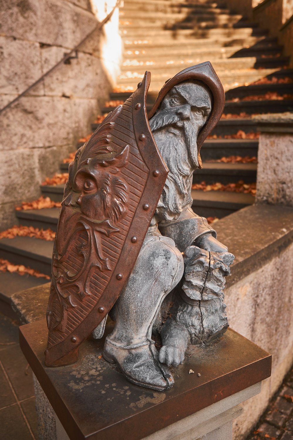 a statue of a man with a shield on his head