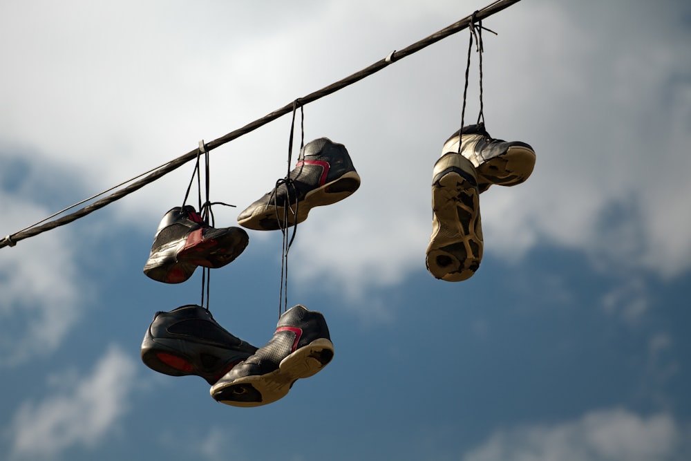 several pairs of shoes hanging from a wire
