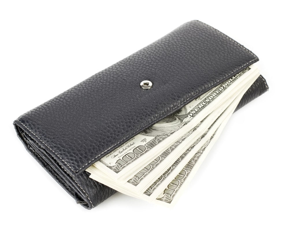 Una billetera con dinero que sobresale de ella
