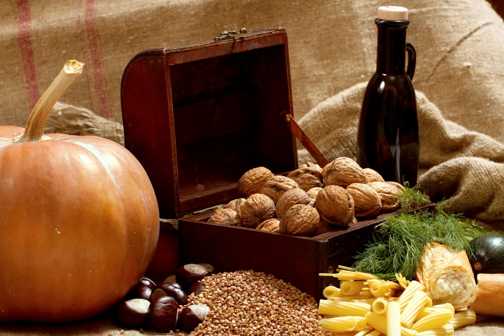 a wooden box filled with nuts next to a bottle of wine