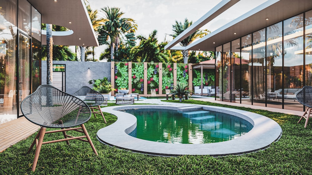 a pool in the middle of a lawn with chairs around it