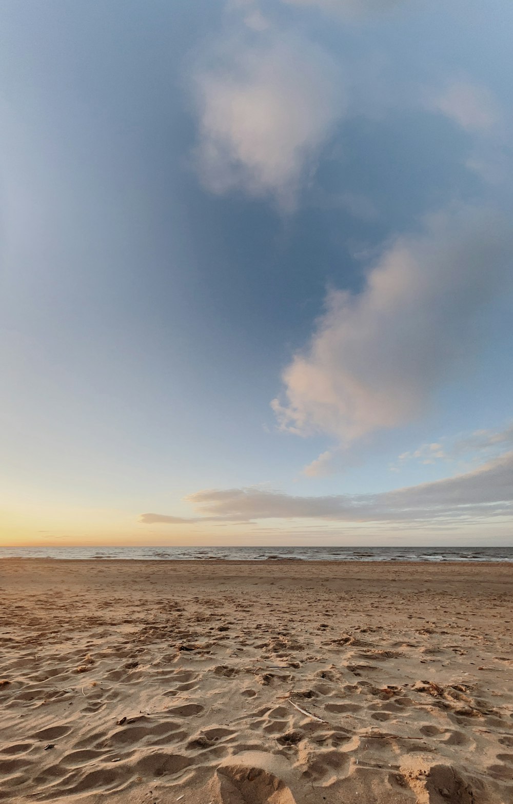 a sandy beach with footprints in the sand