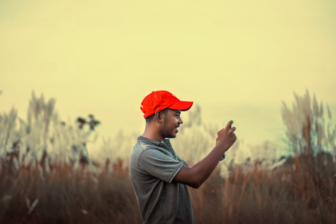 a man in a red hat is standing in a field,