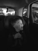 a little boy sitting in a car seat