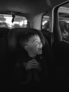 a little boy sitting in a car seat