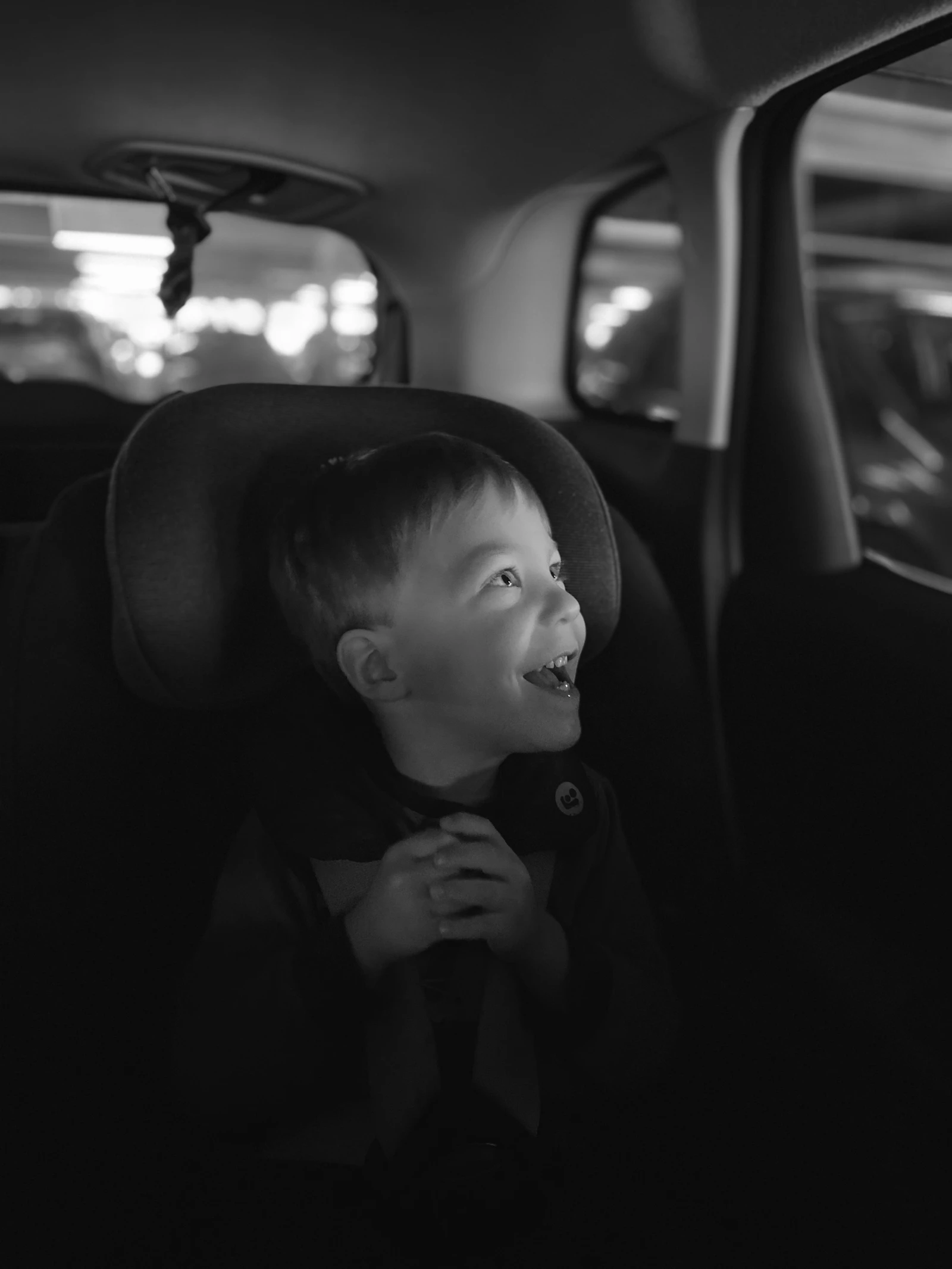 Little boy securely buckled into a car seat for a road trip