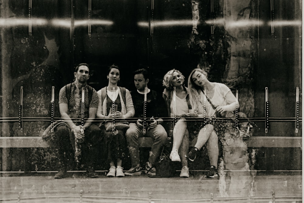 a group of people sitting next to each other on a bench