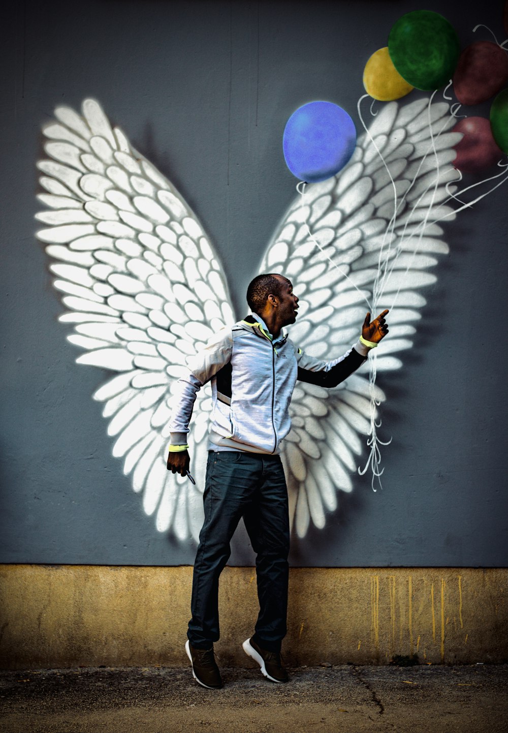 a man standing in front of a wall with balloons