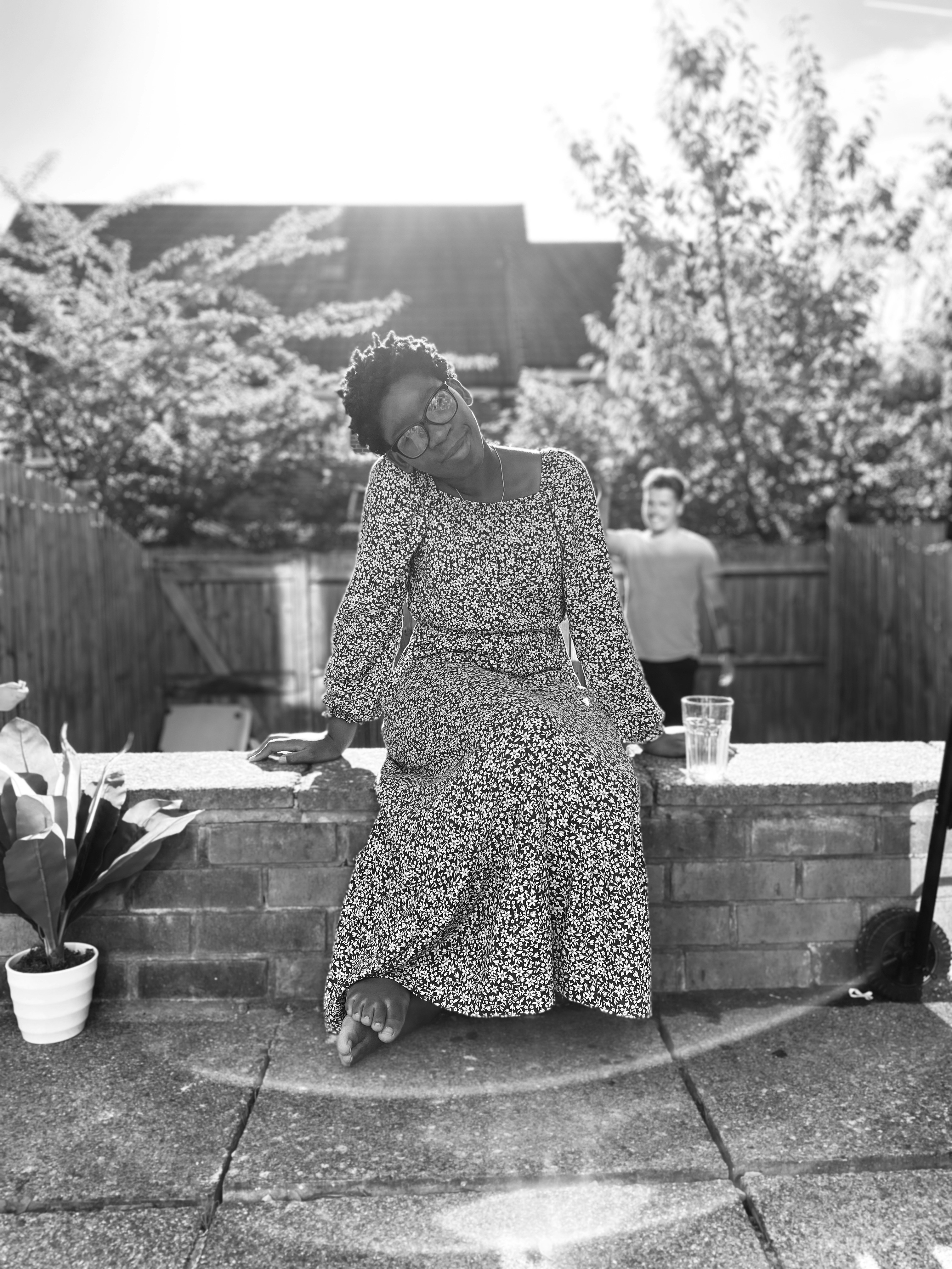 ein Schwarz-Weiß-Foto einer Frau, die an einer Wand sitzt